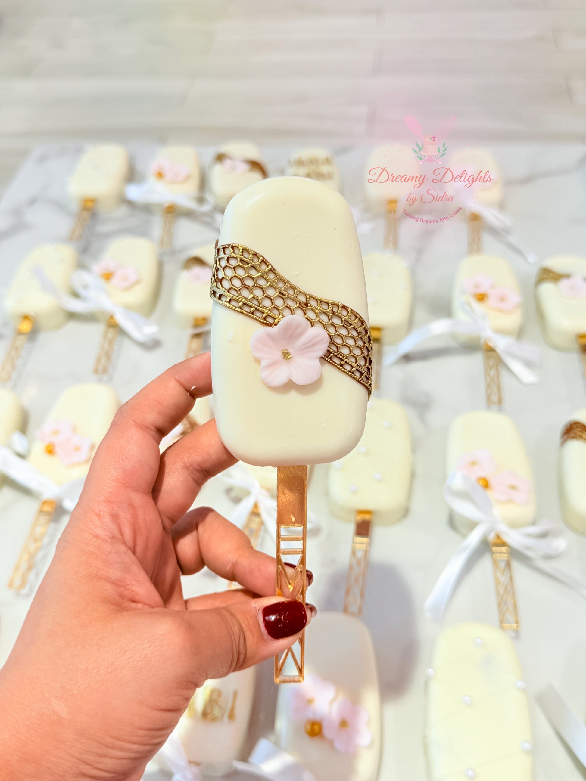 Luxury wedding favor cakesicles with white chocolate and floral design Dubai