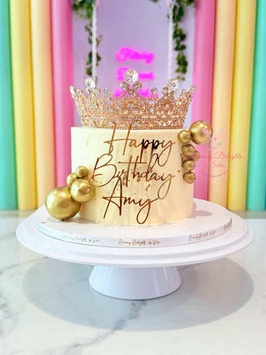 White and gold crown glitter blowout birthday cake for her with custom name topper in Dubai