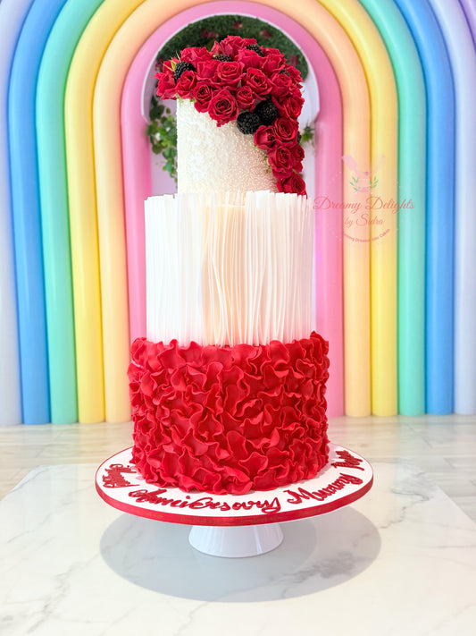 Multistory cake with red and white design against a rainbow arch background